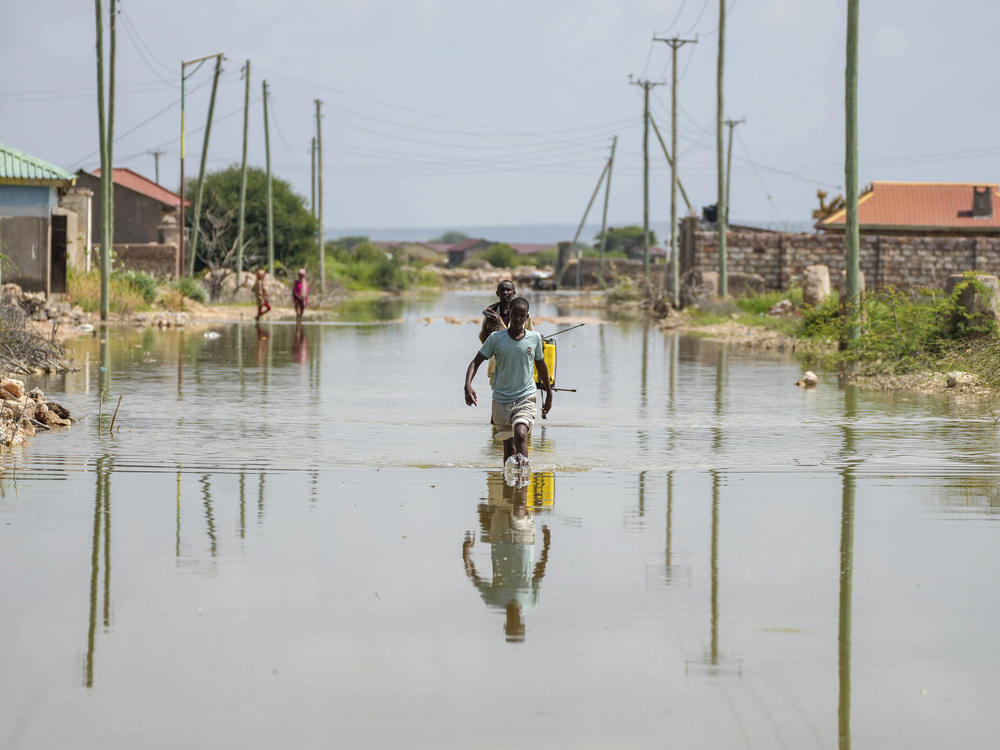 People wade through a section of a road destroyed by floods in Mandera County, Kenya, Wednesday.