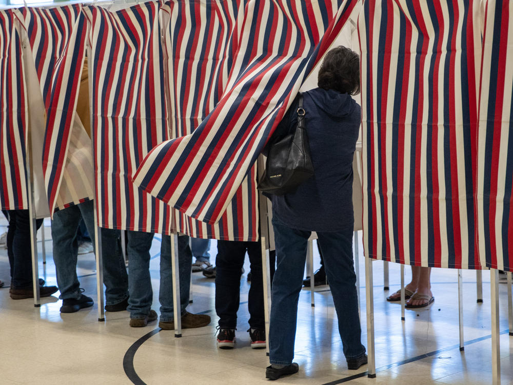 A voter enters a booth to fill out their ballot in Manchester, N.H., in 2022.