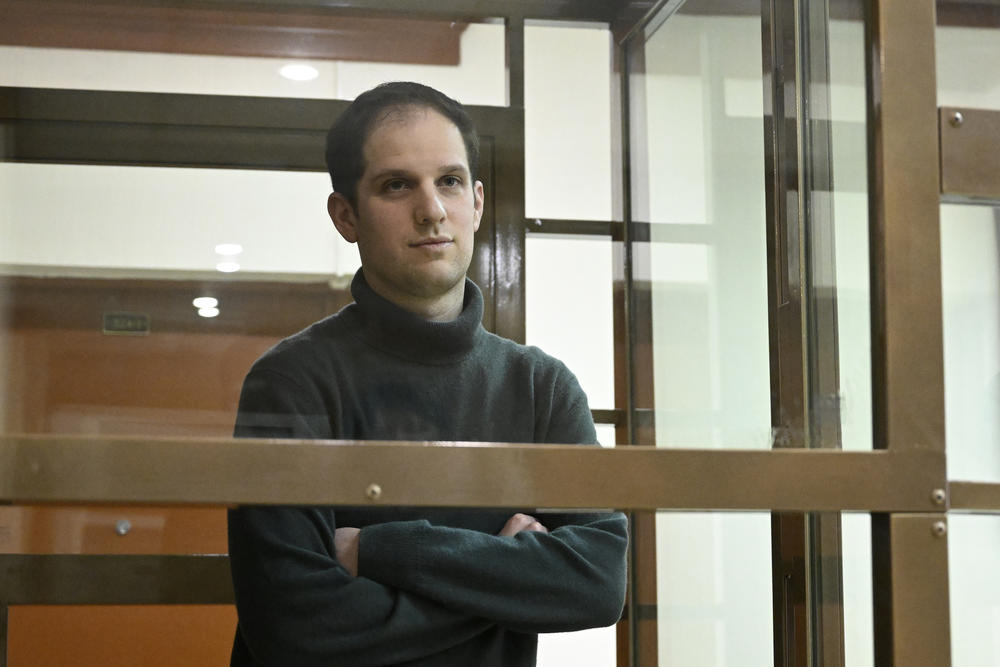 <em>Wall Street Journal</em> reporter Evan Gershkovich stands in a glass cage in a courtroom at the Moscow City Court on Thursday. The court upheld an earlier ruling to hold Gershkovich in pre-trial detention until at least Jan. 30, 2024.