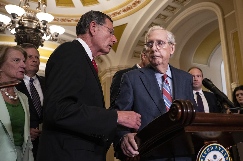 Sen. John Barrasso, R-Wyo., reaches out to help Senate Minority Leader Mitch McConnell, R-Ky., after McConnell froze and stopped talking at the microphones during a news conference after a lunch meeting with Senate Republicans in July.