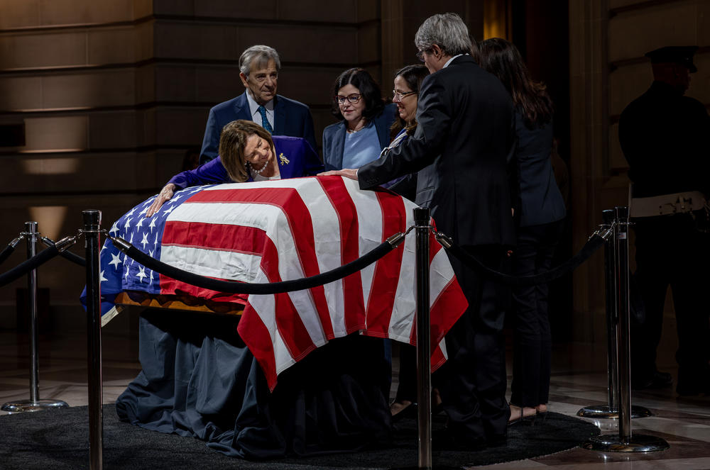 With her husband by her side and Dianne Feinstein's daughter Katherine, former House Speaker Nancy Pelosi lays across Feinstein's casket at City Hall on Oct. 4 in San Francisco.