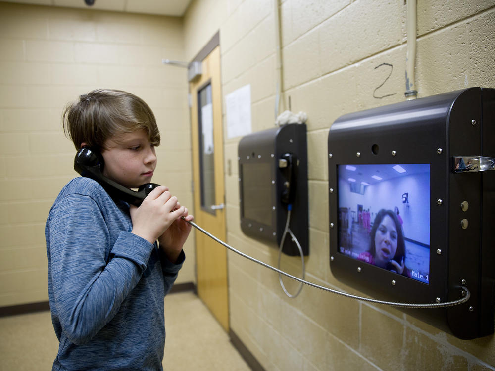 A boy uses a video screen to talk with his mother, who was held at the Campbell County Jail in Jacksboro, Tenn.