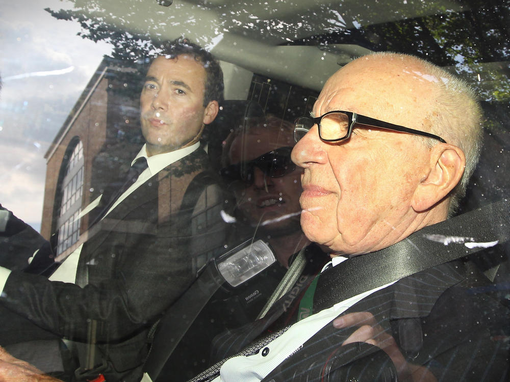 Will Lewis (left) rides with controlling News Corp. owner Rupert Murdoch as they leave the headquarters of his company's British publishing arm in July 2011. Murdoch tasked Lewis with helping to clean up a massive hacking scandal.