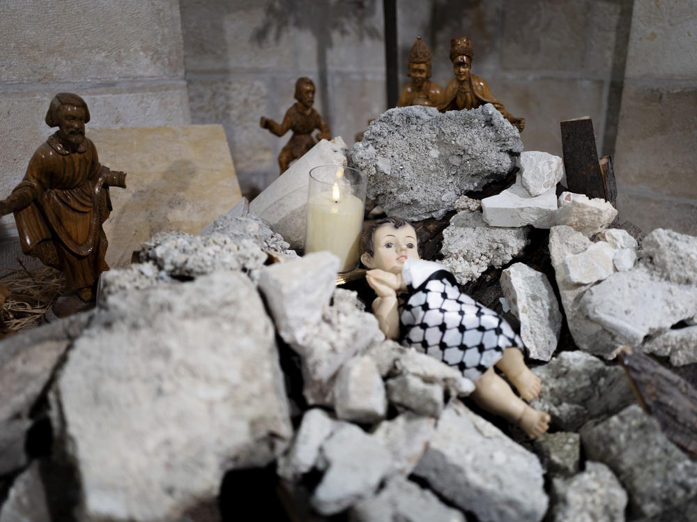 A view of the Evangelical Lutheran Christmas Church's Nativity scene in Bethlehem. This year, it portrays a baby Christ born under rubble and wrapped up in a Palestinian <a href=