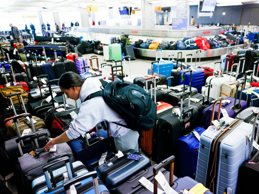 Pristine Floyde searches for a friend's suitcase in a baggage holding area for Southwest Airlines at Denver International Airport in December 2022.