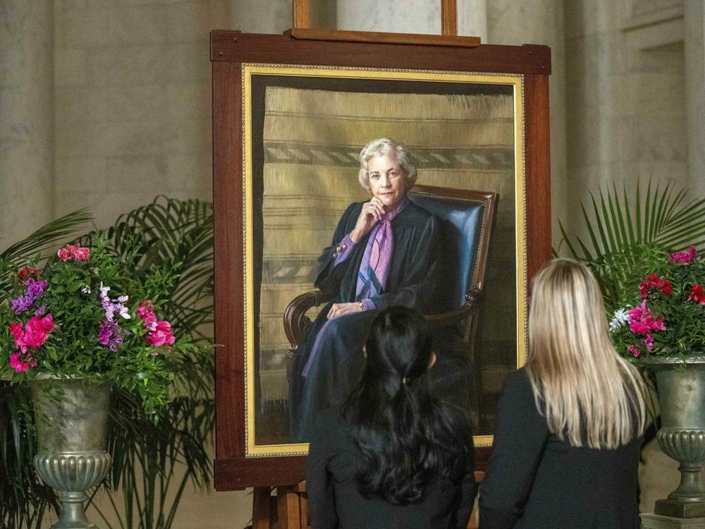 Mourners look at a portrait of O'Connor as her body lies in the Great Hall at the U.S.  Supreme Court on Monday.