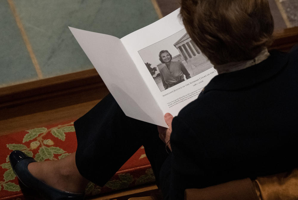 An attendee looks at a program before the start of the funeral service of late Supreme Court Justice Sandra Day O'Connor.