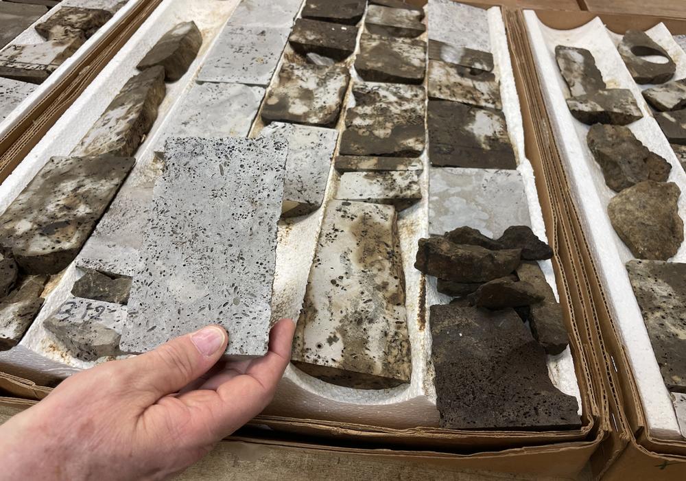 Geologist Bob Trentham holds up a core sample in his lab in Odessa, Texas. These samples came from a rock formation that had already had oil extracted from it. The section he's holding has been cleaned; behind it, you can see the samples that are still stained with oil that was trapped in the rock and could not reach the well.
