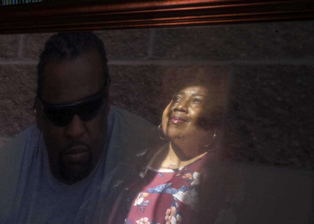 Jackson's reflection is seen on a portrait of her late husband. John Jackson died of a staph infection he contracted while in prison; his records said his death was 