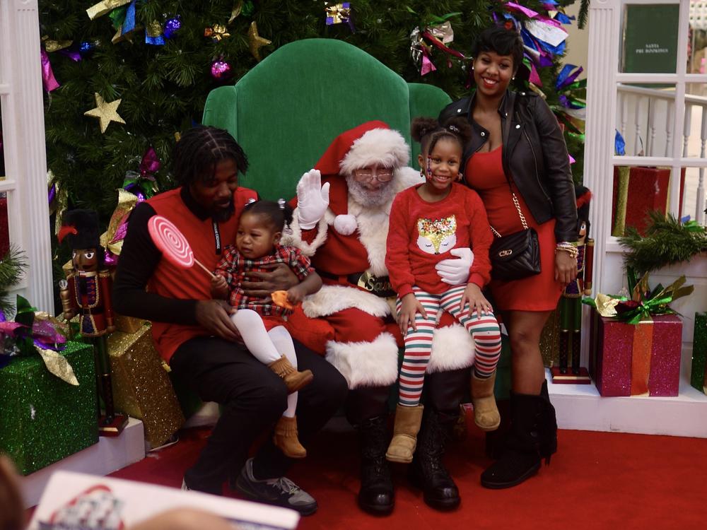 Ken Lee, far right, drove from Delaware with her family to take photos with Santa Luke at Mondawmin Mall.
