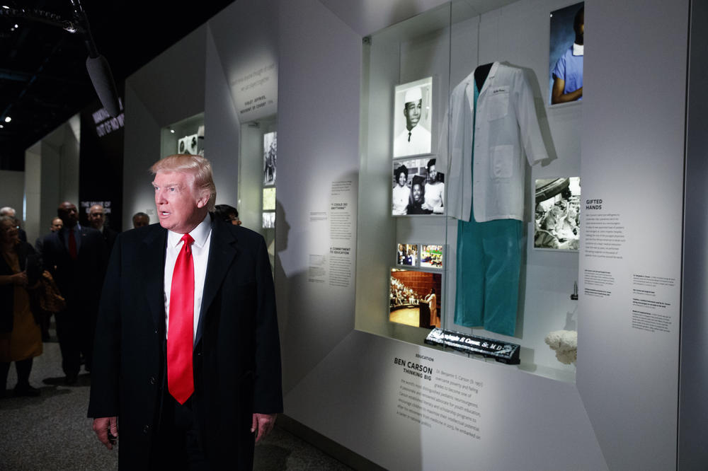 In this Feb. 21, 2017, file photo, President Donald Trump talks with reporters as he stops at the exhibit for Dr. Ben Carson, his nominee for Housing and Urban Development secretary, during a tour of the National Museum of African American History and Culture in Washington.