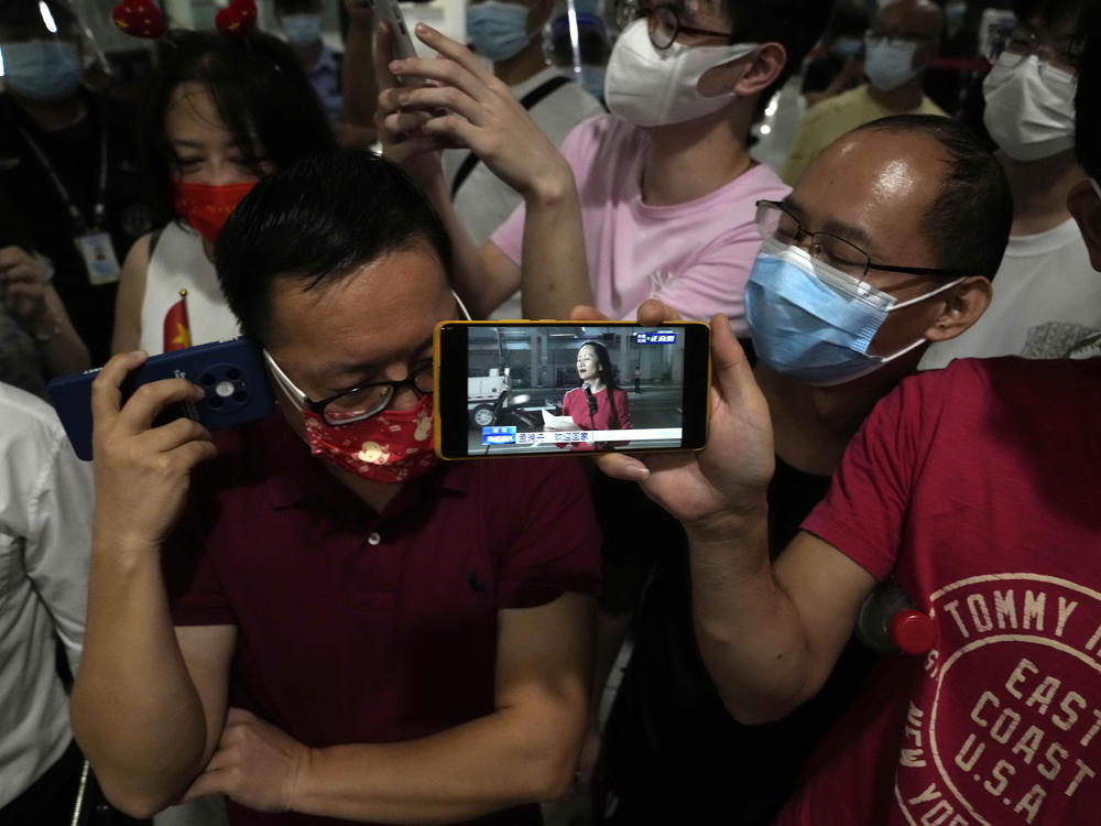 Supporters of global communications giant Huawei CFO Meng Wanzhou watch a live broadcast of her return as they gather at Shenzhen Bao'an International Airport in southern China's Guangdong Province, Sept. 25, 2021. She returned to China following what amounted to a high-stakes prisoner swap with Canada and the U.S.