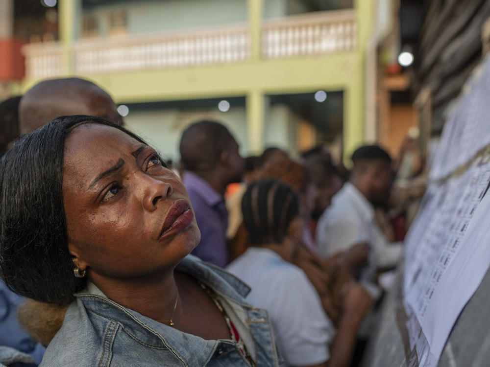 A woman looks for her name at a voting station in Goma, eastern Democratic Republic of the Congo, Wednesday, Dec. 20, 2023.