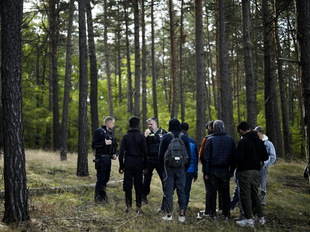 A Federal Police officer speaks into his radio as he and a colleague track down a group of migrants who illegally crossed the border from Poland into Germany, southeast of Berlin, Oct. 11. On Wednesday, European Union leaders hailed a major breakthrough in talks on new rules to control migration.