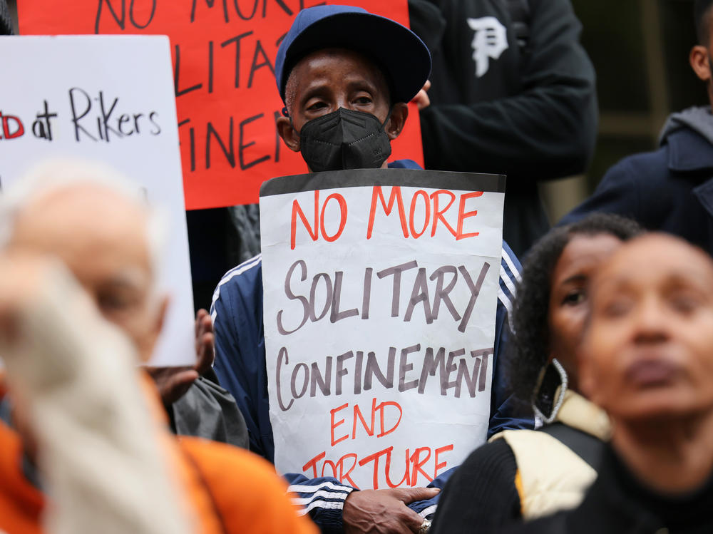 People gather for a rally to protest conditions at New York City's Rikers Island jail in October of 2022. The New York City Council voted Wednesday to ban most uses of solitary confinement in the city's jails.