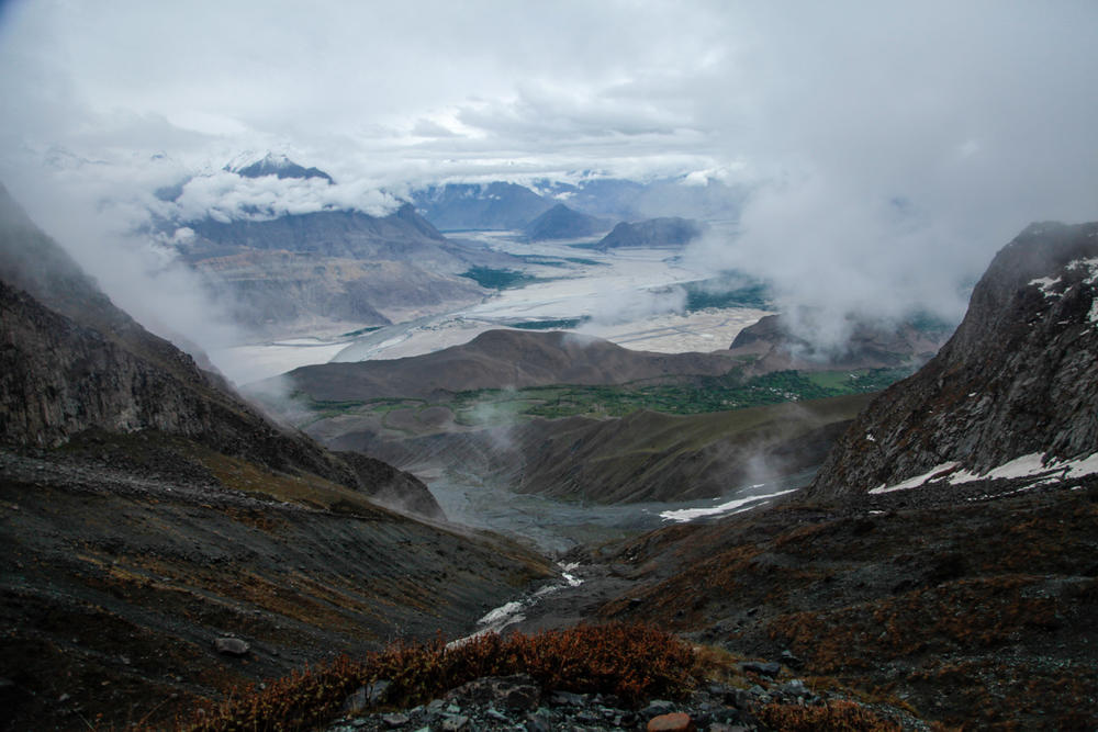 A view of the Pakistani territory of Baltistan from the heights of the mountain above the village of Chunda, where the ancient ritual of glacier mating is being revived. The patches of white in the foreground are snow and water. The patches of silver in the distance are clouds that shroud the peaks of most mountains in Baltistan.