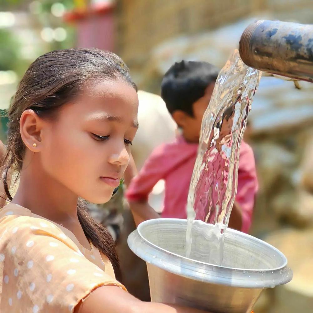 Rohingya children collect water for their families from an emergency water distribution point in the refugee camp.