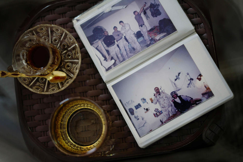 A photo album of Shihab — during his time as an interpreter working with American military personnel during the Iraq War — rests on a small table alongside cups of tea.