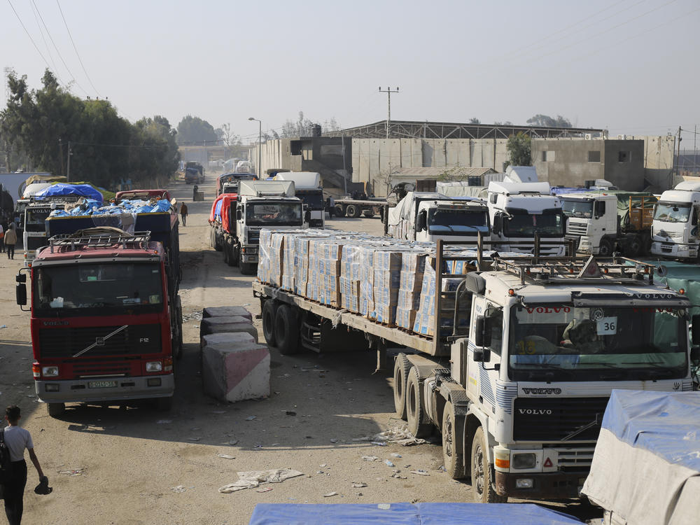 Aid trucks enter through the Kerem Shalom crossing from Israel into the Gaza Strip on Dec. 18. The Security Council's vote on a new U.N. resolution to spur desperately needed aid to Gaza went through intense negotiations around two issues important to the U.S. — a reference to a cessation of hostilities and putting the U.N. in charge of inspecting trucks.