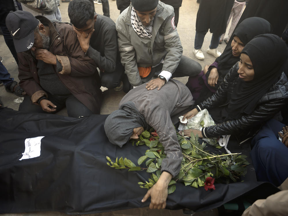 Palestinians mourn relatives killed in the Israeli bombardment of the Gaza Strip outside a morgue in Khan Younis on Sunday, Dec. 24, 2023.