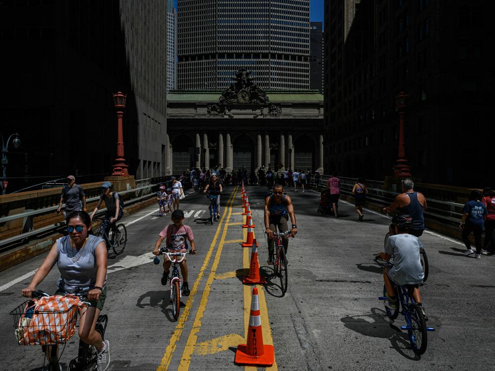 Many cities hope that ditching their parking requirements will make their neighborhoods more amenable to biking and walking. People are seen biking and walking along Park Avenue near Grand Central Station during the Summer Streets initiative in New York City in August 2022.