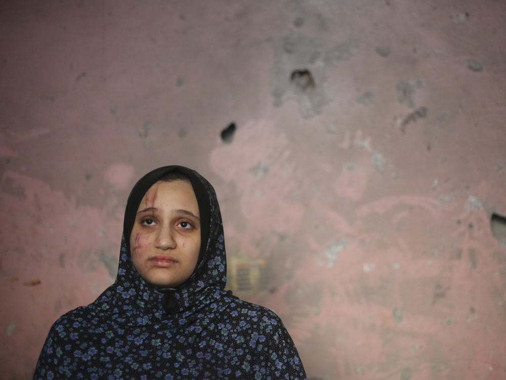 A Palestinian woman stands in her home after an Israeli strike in Rafah, Gaza Strip, on Sunday.