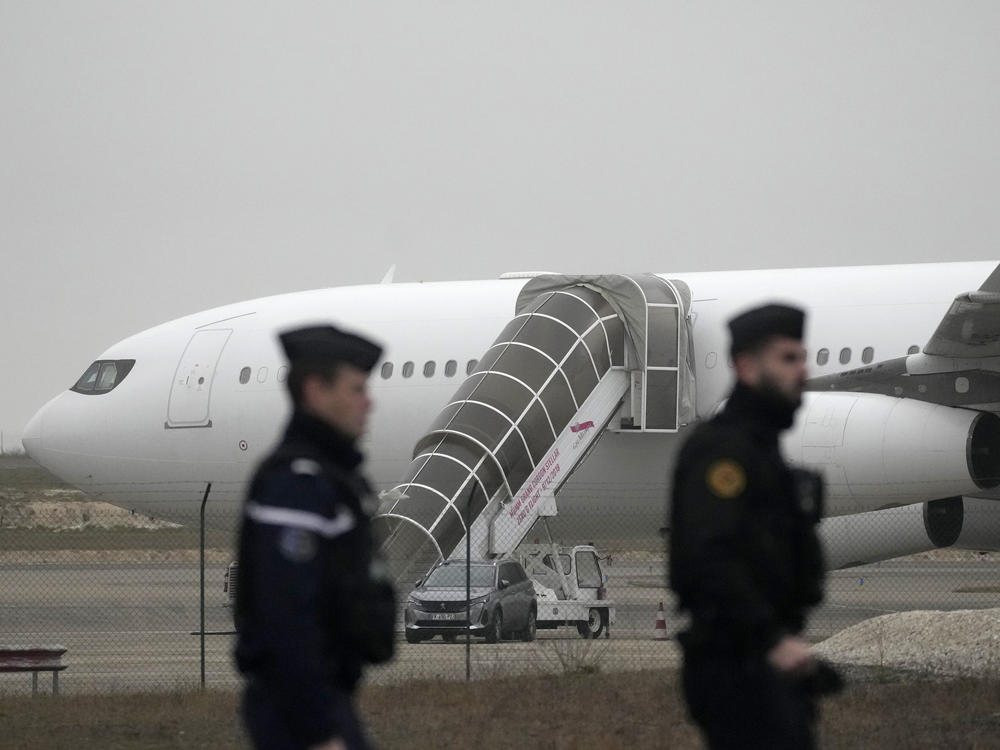 Gendarmes patrol by the plane grounded by police based that it could be carrying trafficking victims, at the Vary airport , Monday, Dec. 25, 2023 in Vatry, eastern France.