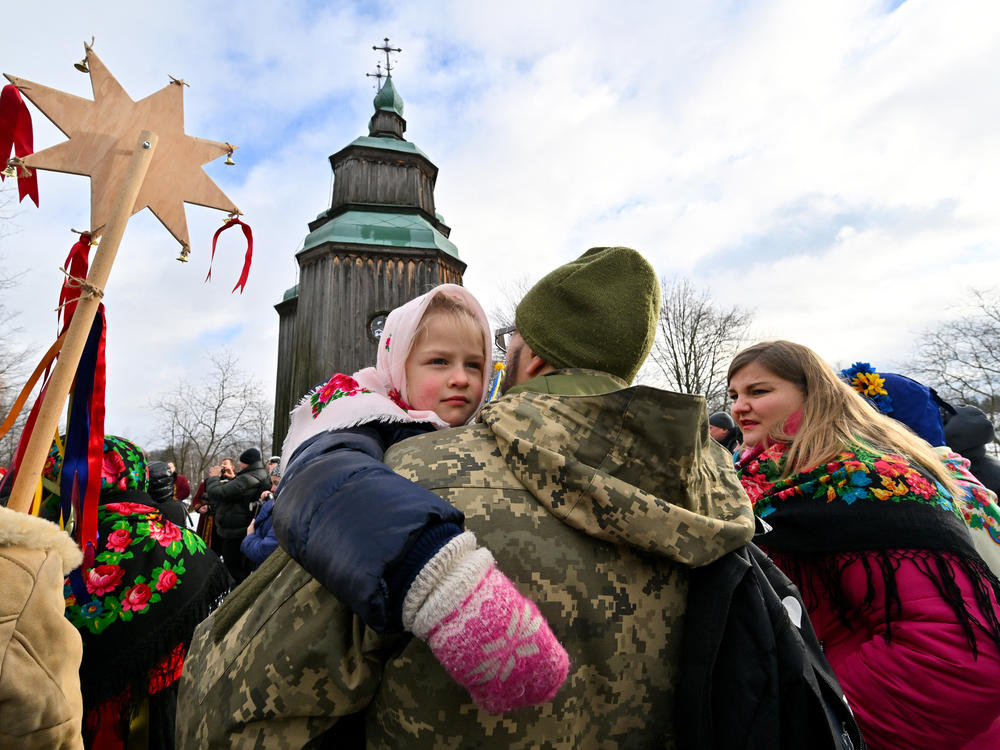 A Ukrainian serviceman holds his daughter as they take part in Christmas celebrations in the village of Pyrogove, near Kyiv on Monday.