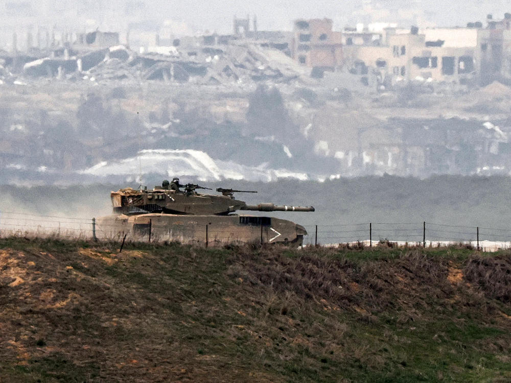 An Israeli battle tank moves along the border between the Gaza Strip and southern Israel on Wednesday as battles between Israel and Hamas continue.