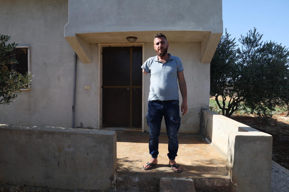 HATAN, SYRIA — Barakat Ahmad Barakat is pictured in front of his house in the village of Hatan in the West valley of Barisha, on June 24th. He explains where and how his arm was blown off and his two friends were killed by U.S. helicopter fire during the attack of the compound of ISIS leader Abu Bakr al-Baghdadi on October 2019. <a href=