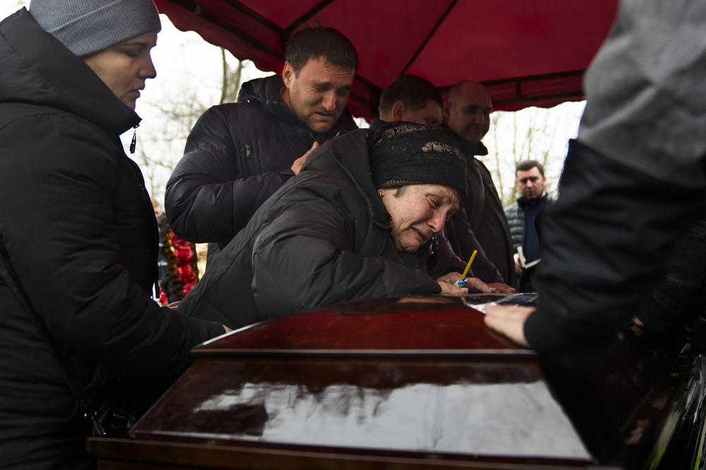 DNIPRO, UKRAINE — In a cemetery on the outskirts of the Ukrainian city of Dnipro, Mykhailo Korenovsky's mother sobs over his coffin at his funeral. Mourners gathered for the burial of Korenovsky, a boxing coach who was killed in a Russian missile strike on an apartment building. <a href=