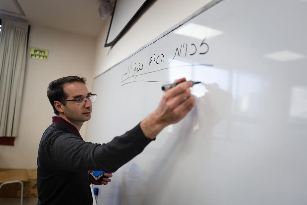 Teacher Daniel De Shalit writes in Hebrew and Arabic during a class at Hand in Hand.