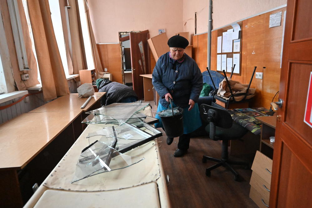 Kharkiv: A local resident removes shards of glass from the windows of an oncology center damaged after a missile strike.