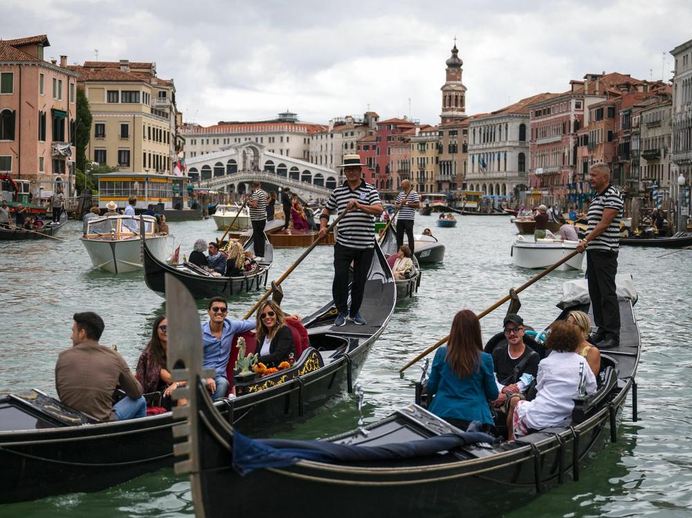 Tourists enjoy a gondola ride on the Grand Canal by the Rialto bridge in Venice in 2021.