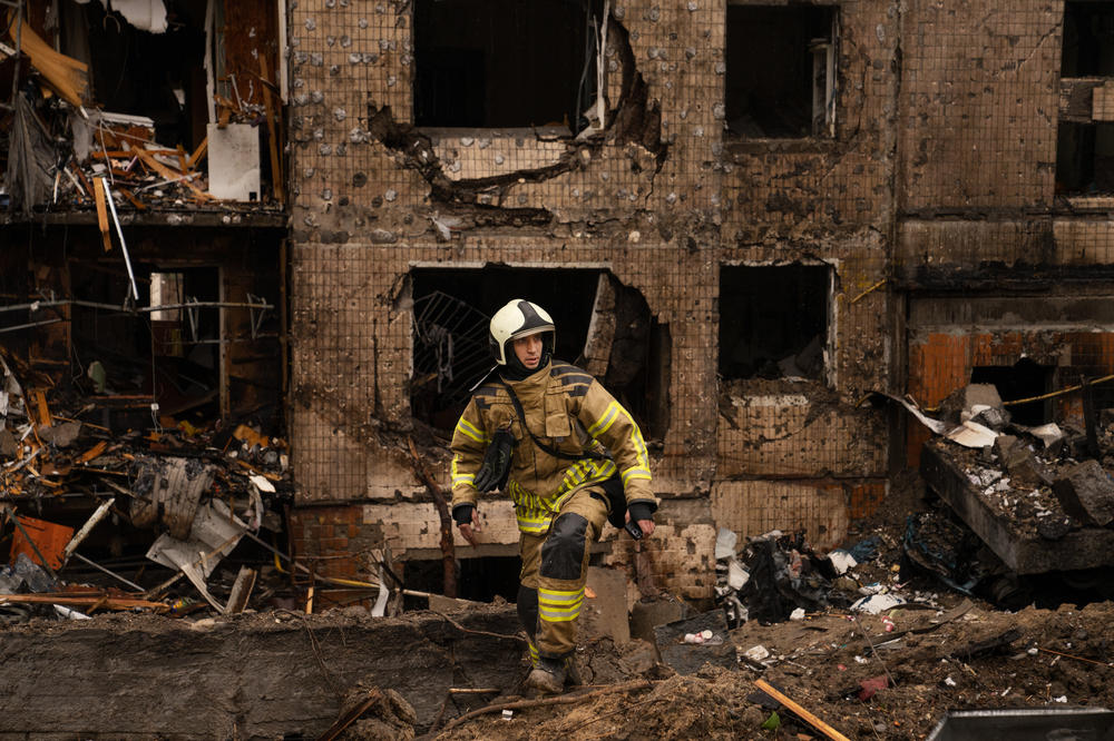 Firefighters and emergency service workers work the scene at a residential building in Kyiv that was damaged in a Russian missile strike on Tuesday.