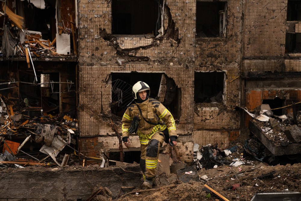 Firefighters and emergency service workers work the scene at a residential building in Kyiv that was damaged in a Russian missile strike on Tuesday.