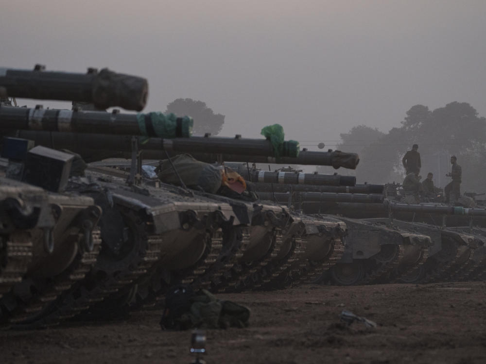 Israeli soldiers stand on top of a tank in a staging area at the Israeli-Gaza border in southern Israel, on Monday.