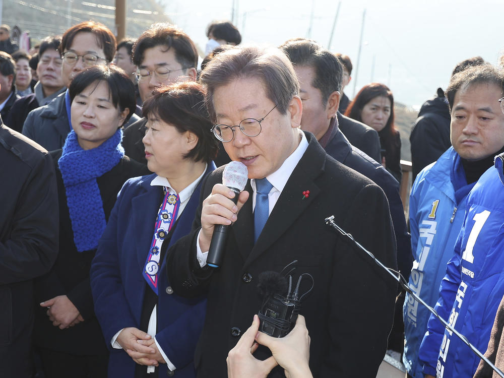 South Korean opposition leader Lee Jae-myung, center, speaks as he visits the construction site of a new airport in Busan, South Korea, Tuesday, Jan. 2, 2024. Lee was attacked and injured by an unidentified man during a visit Tuesday to the southeastern city of Busan, emergency officials said.