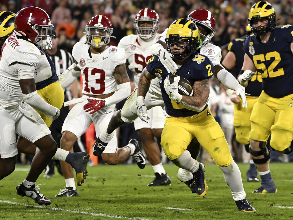Michigan running back Blake Corum (2) runs in for a touchdown past Alabama defensive back Kool-Aid McKinstry (1) during overtime at the Rose Bowl CFP NCAA semifinal college football game Monday, Jan. 1, 2024, in Pasadena, Calif.