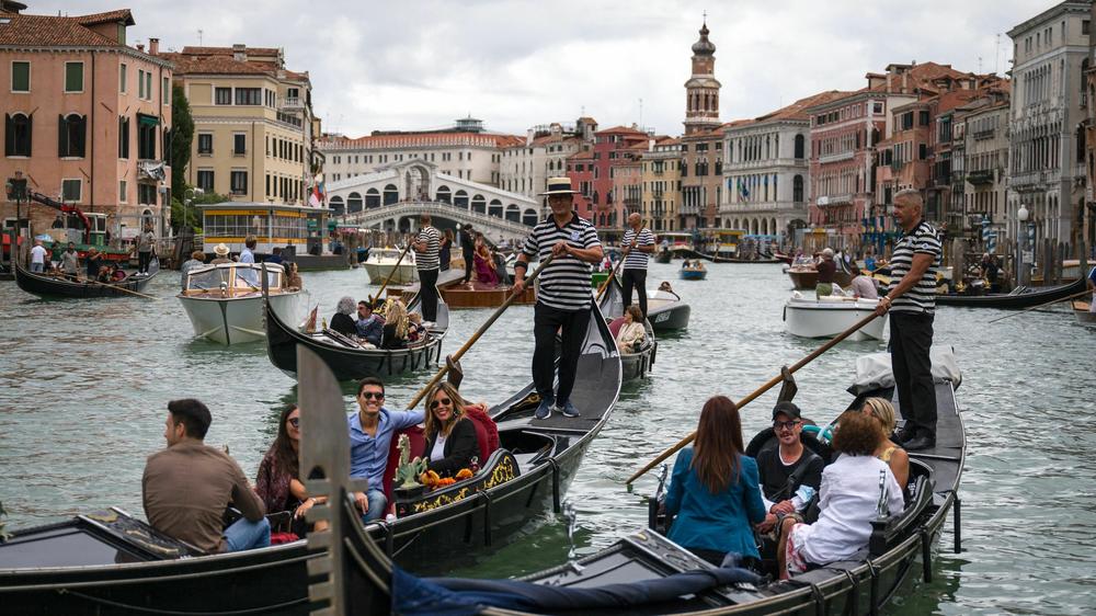 Tourists enjoy a gondola ride on the Grand Canal by the Rialto bridge in Venice in 2021.