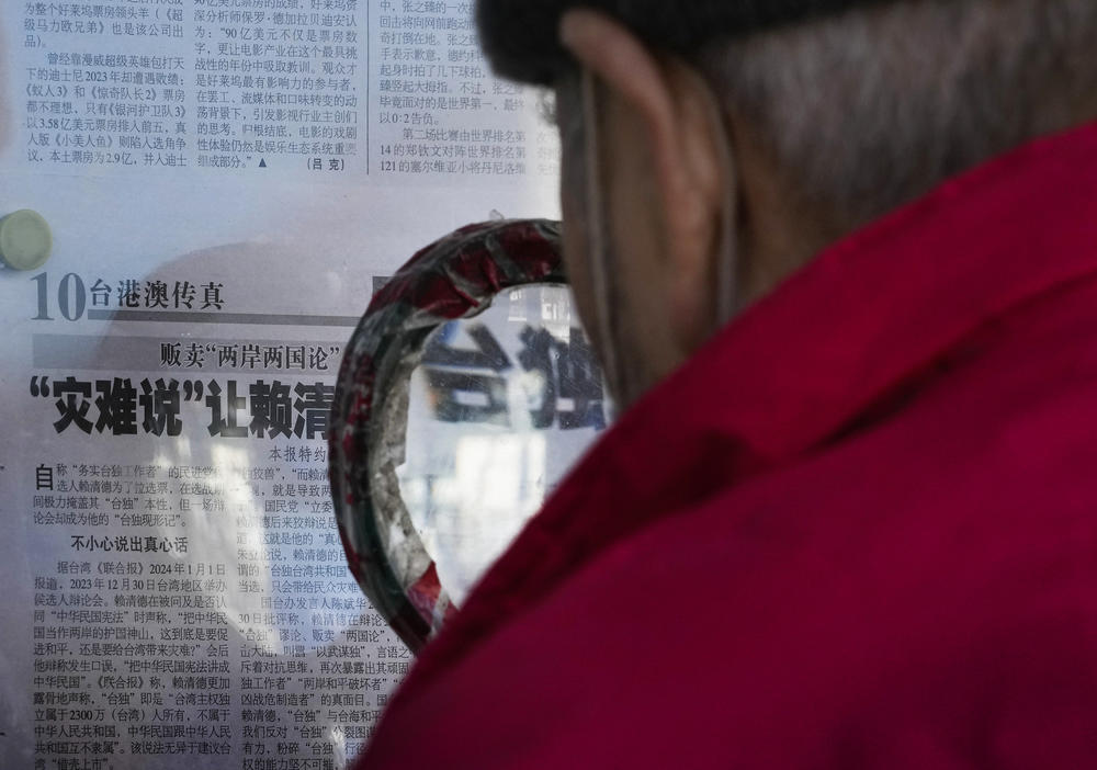 A resident uses a magnifying glass showing the Chinese characters of Taiwan 