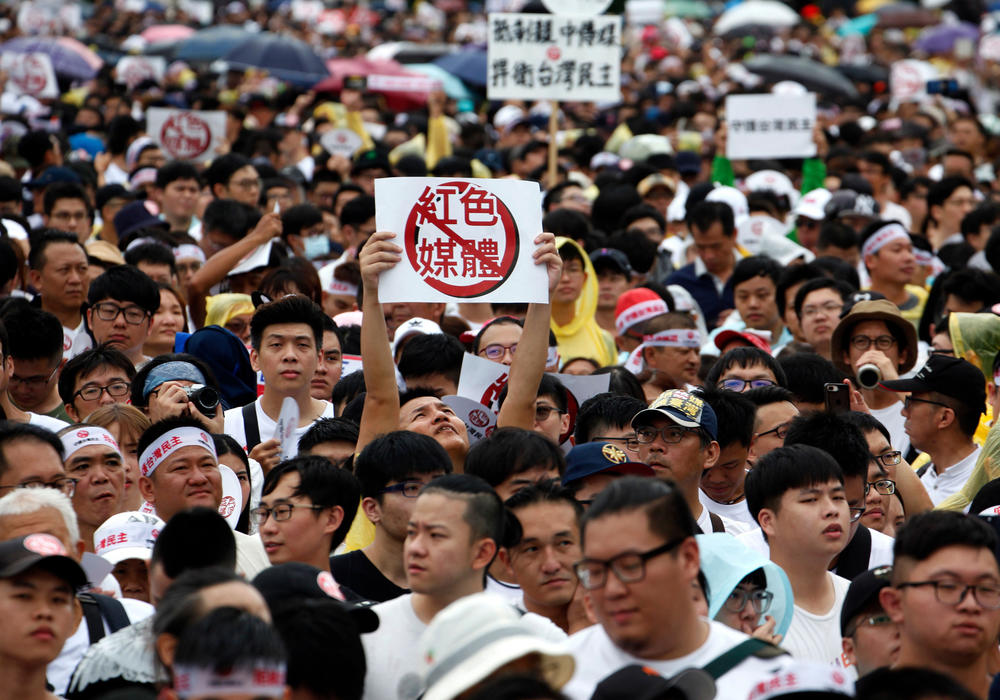 Protesters hold placards with messages that read 