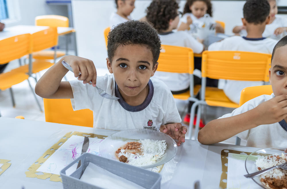Davi Lucas has lunch in the dining area with his classmates. He says the food at school has encouraged him to eat healthier.