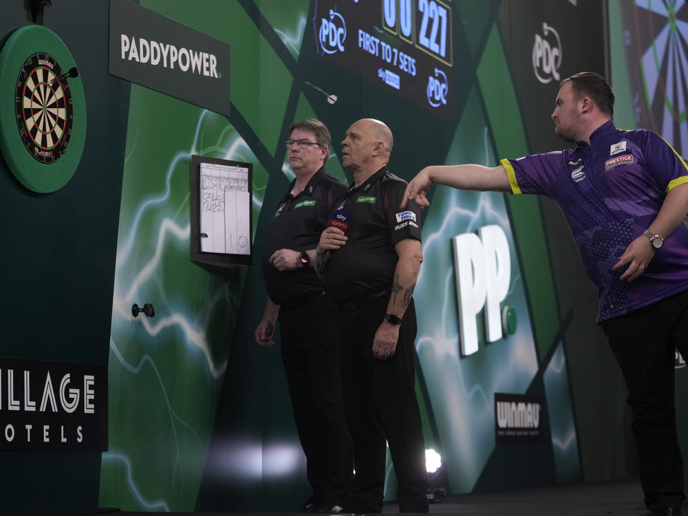 Luke Littler of England throws his dart during the final match against Luke Humphries of England at the World Darts Championship, in London, Wednesday.
