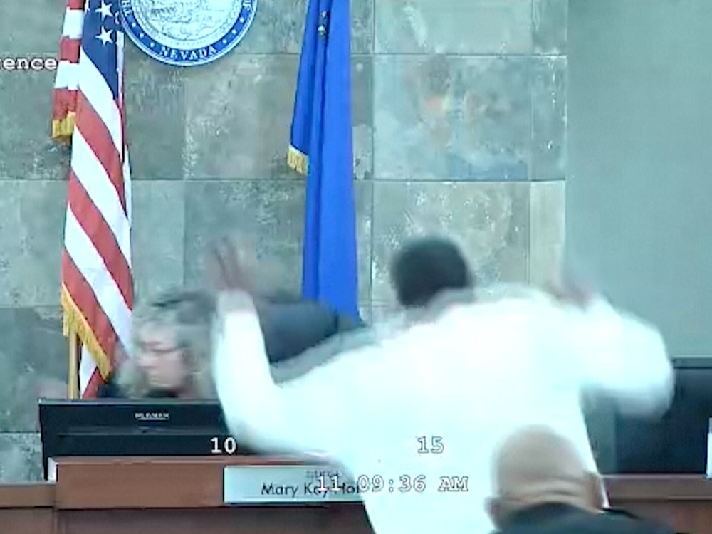 A defendant identified by court officials and records as Deobra Redden is seen about to leap over the desk of Judge Mary Kay Holthus during his sentencing in a felony battery case on Wednesday in Las Vegas. Authorities say the judge suffered minor injuries while a courtroom marshal suffered a bleeding gash on his forehead and a dislocated shoulder.