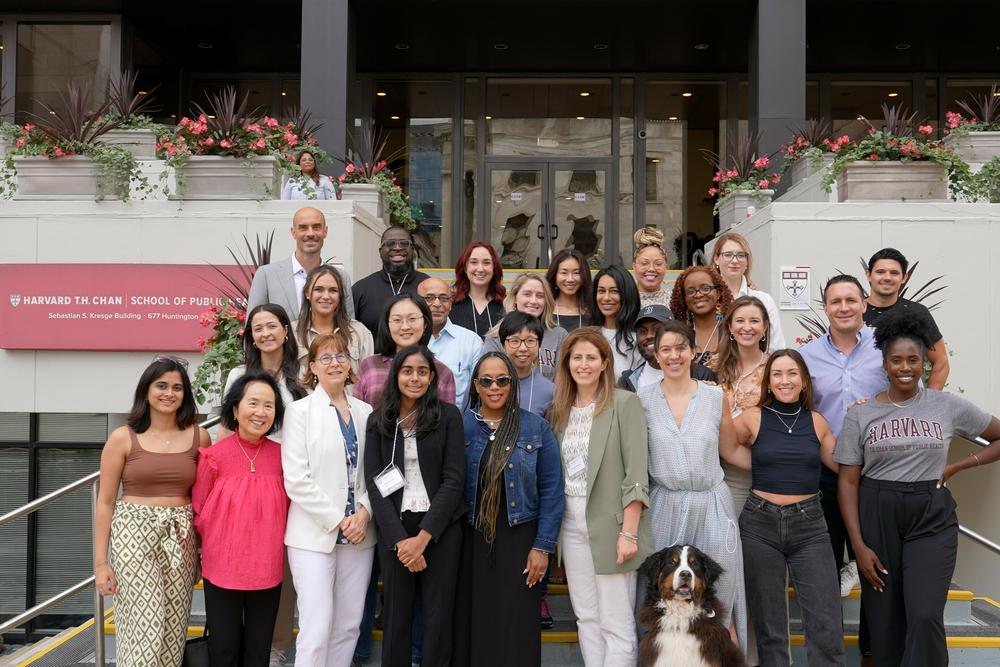 Attendees at a summit for mental health influencers hosted by researchers at the Harvard T.H. Chan School of Public Health. In the front row, right of center, Amanda Yarnell stands next to Kate Speer and her service dog, Waffle.