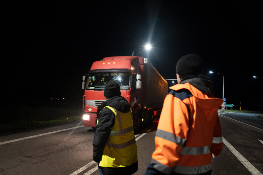 Stasiak (left) and another Polish protestor stop a truck at night at the Dorohusk border in Poland.