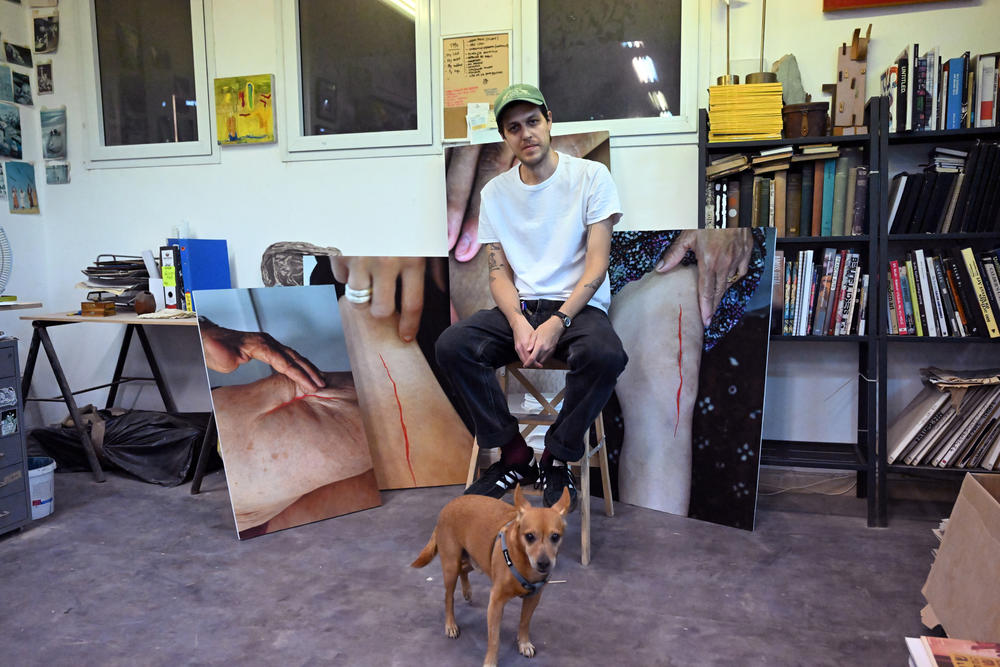 Artist Addam Yekutieli with his dog in his studio. He works with testimonials from Palestinians, Israelis and others, including images of wounds and healing.