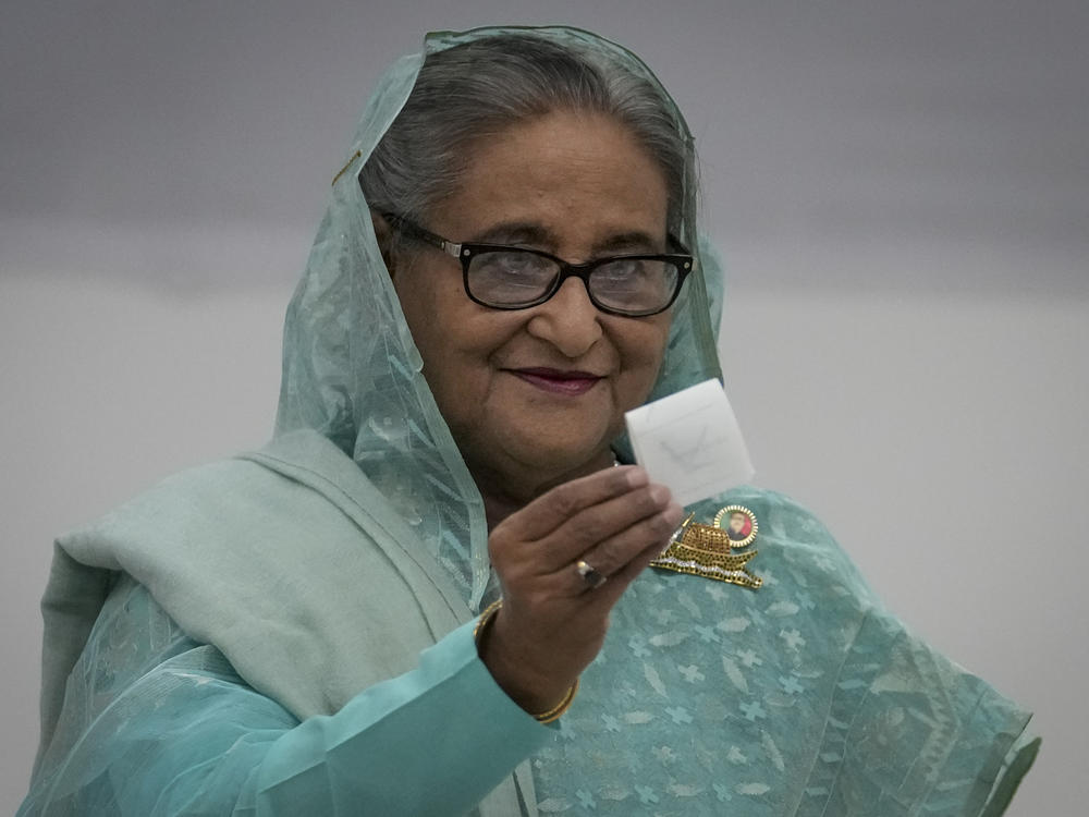 Bangladesh Prime Minister Sheikh Hasina shows her ballot paper as she casts her vote in Dhaka, Bangladesh, Sunday, Jan. 7, 2024. Polls have opened in Bangladesh as voters began casting their ballots in an election fraught with violence and a boycott from the main opposition party.