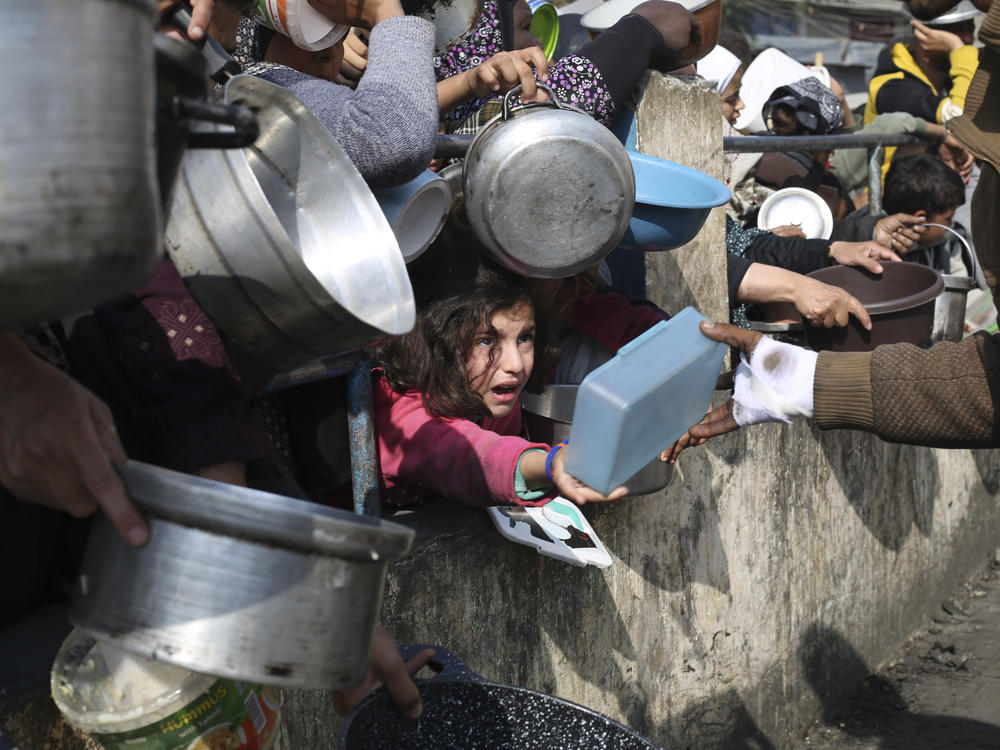 Palestinians line up for free food during the ongoing Israeli air and ground offensive on the Gaza Strip in Rafah on Tuesday.